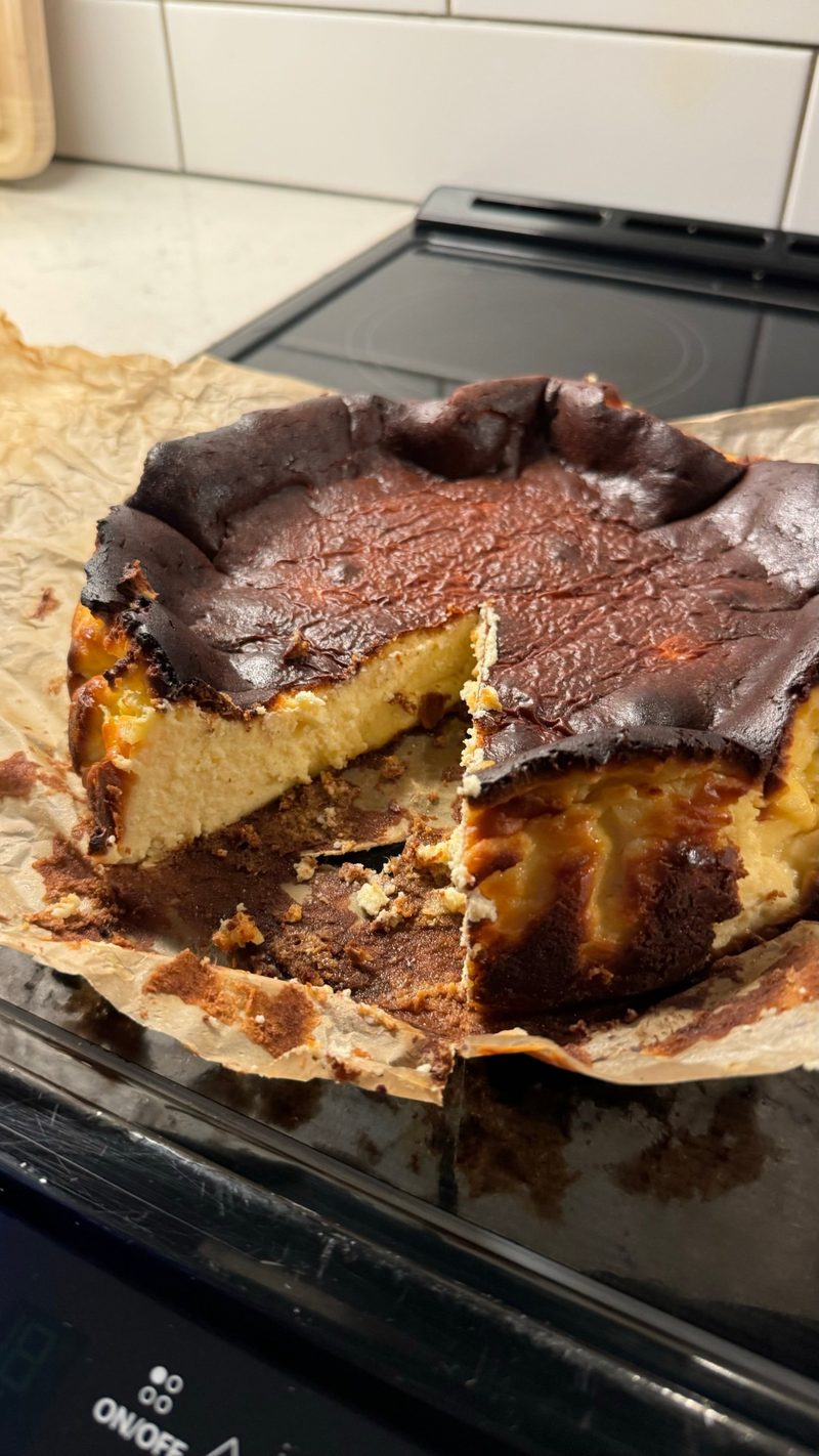 A sliced burnt Basque cheesecake with a dark caramelised top and creamy centre