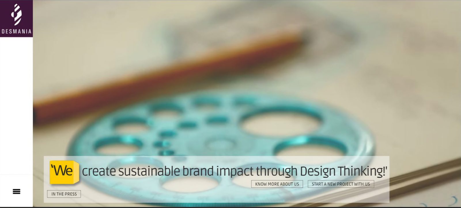 Old Desmania homepage: a blurry stock photo hero behind a maroon logo panel and a small quote overlay reading 'We create sustainable brand impact through Design Thinking!'